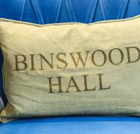 Monogrammed gold-cloth cushion on a blue easy chair