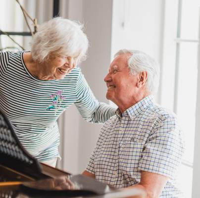 Retired people playing piano and laughing