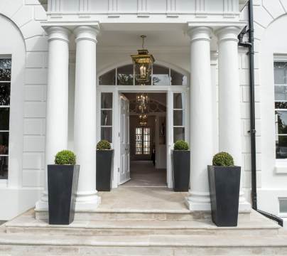 Covered entrance with columns and stone steps