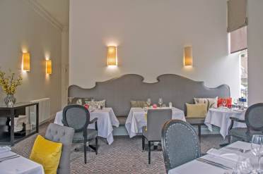 The Fairmile restaurant at Audley Willicombe Park, Tunbridge Wells Dining tables with chairs and long banquette