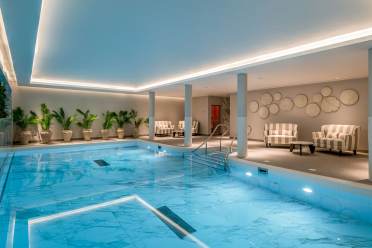 Swimming pool at Audley Sunningdale Park Blue pool with soft lighting and loungers