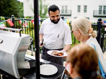 Barbecue with chef handing out cooked food
