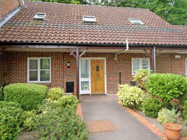 Cottage with shrubs around front path